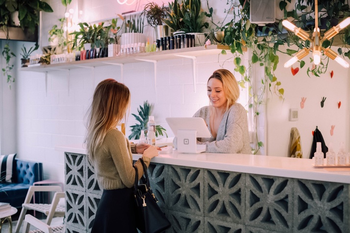 A female customer pays for a product in a white store