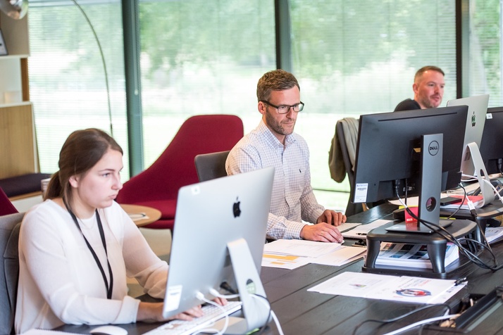 Woman and man on computers in an office providing live chat support